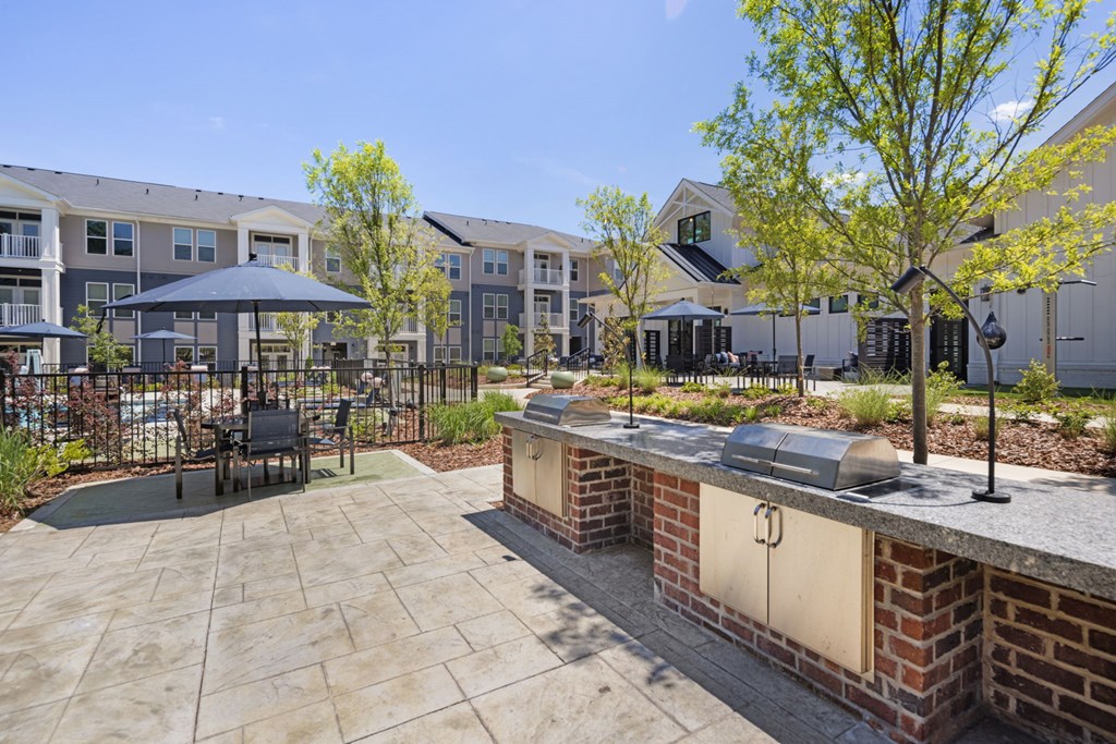 A patio area with a table and chairs is surrounded by apartment buildings.