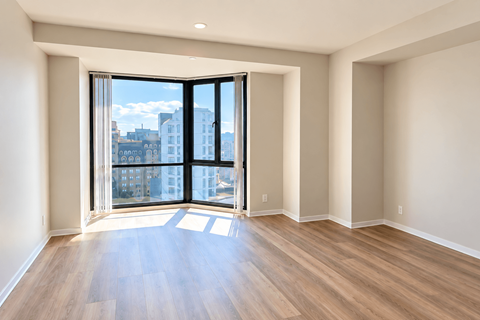 A room with a large window and wooden flooring.