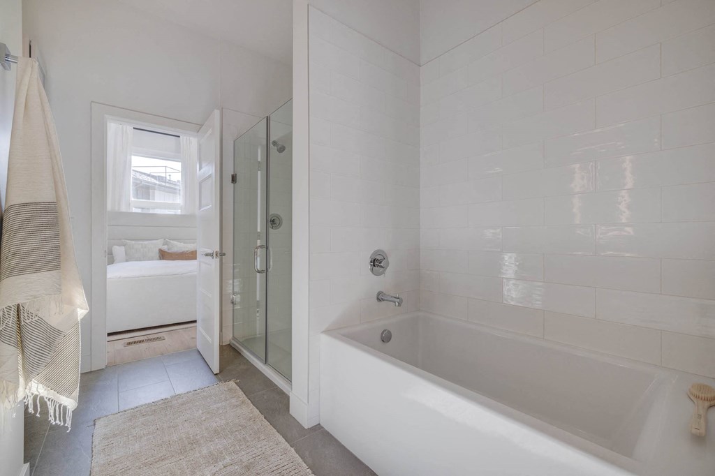 a white bathroom with a tub and a shower