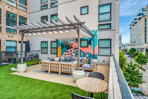 A patio with a table and chairs under a pergola.