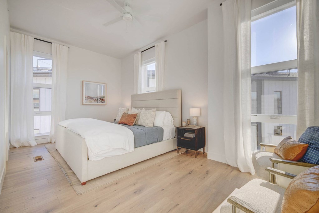 a bedroom with Swiss Krono Wood Plank Flooring and a large window