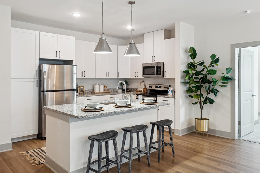 an open kitchen with a center island with three stools