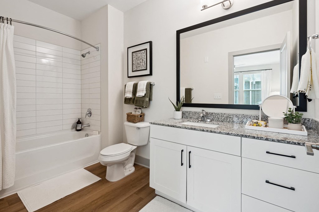 a bathroom with a large mirror and a toilet and a bath tub