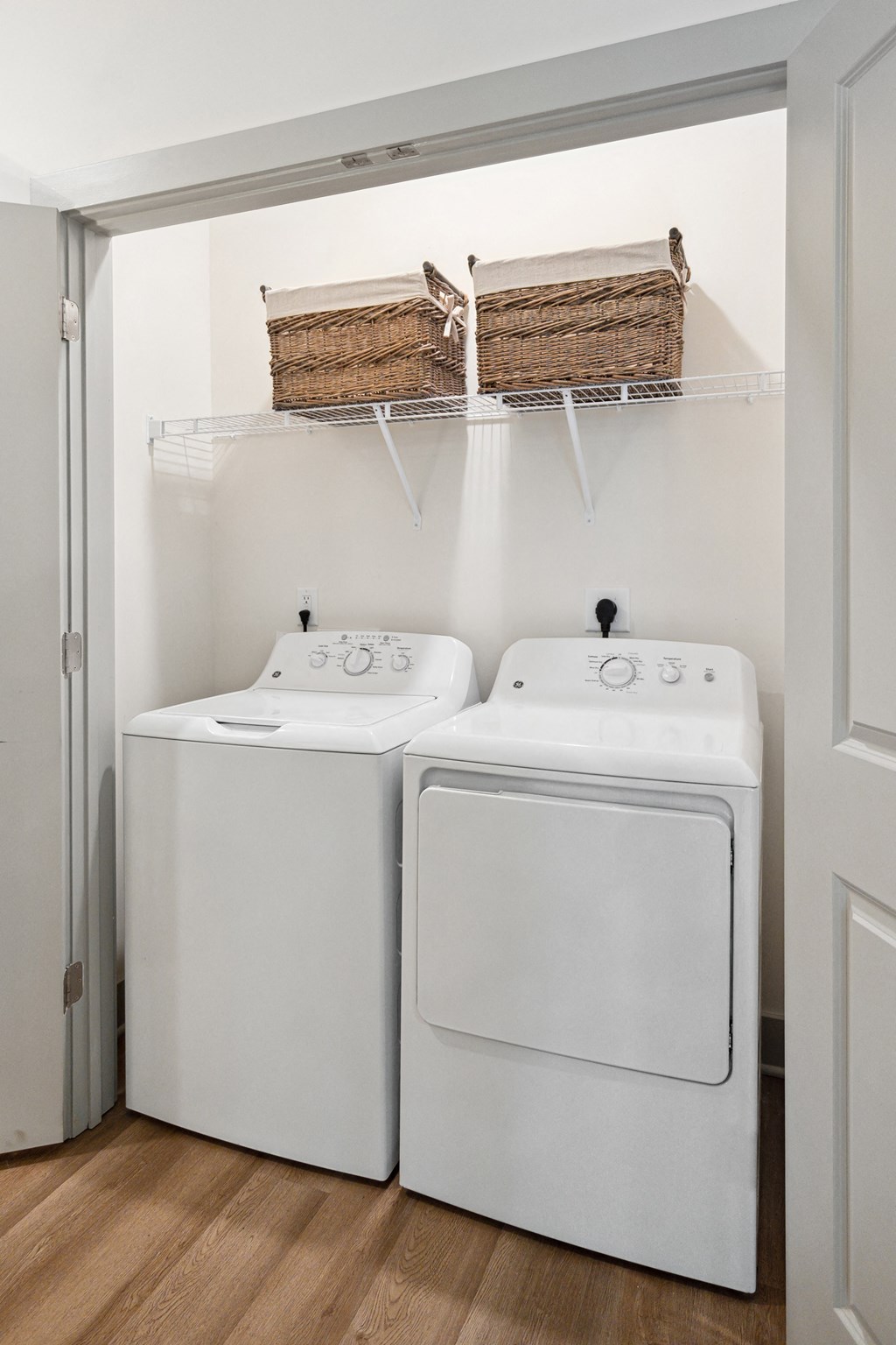 a washer and dryer in a laundry room with two baskets on the wall