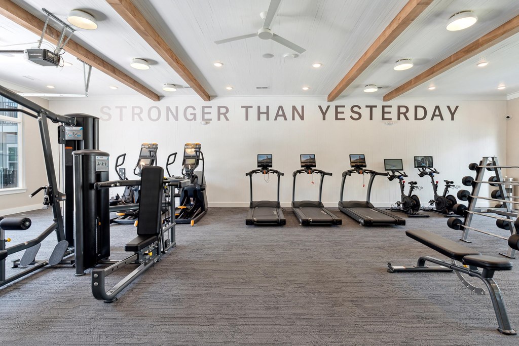 a gym with cardio machines and weights on the floor