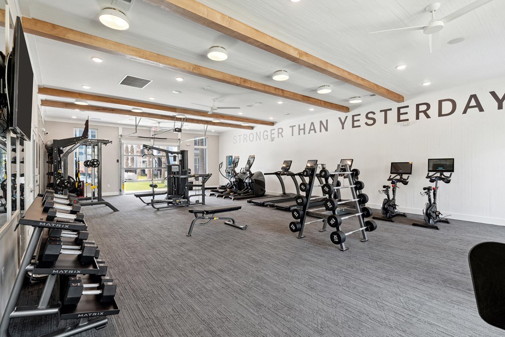 the gym with weights and treadmills at the belgard apartments
