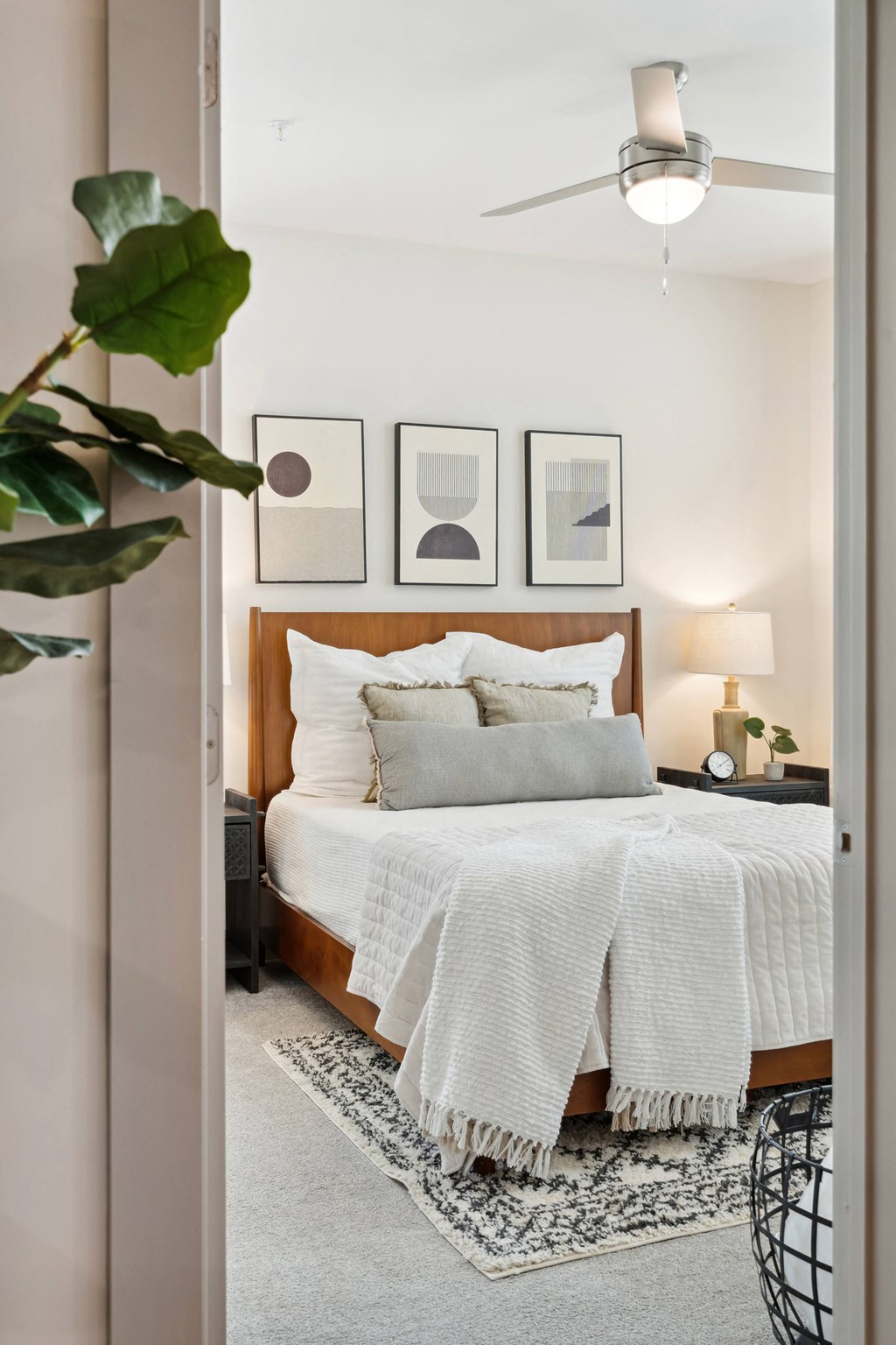 a bedroom with a bed with a white comforter and pillows
