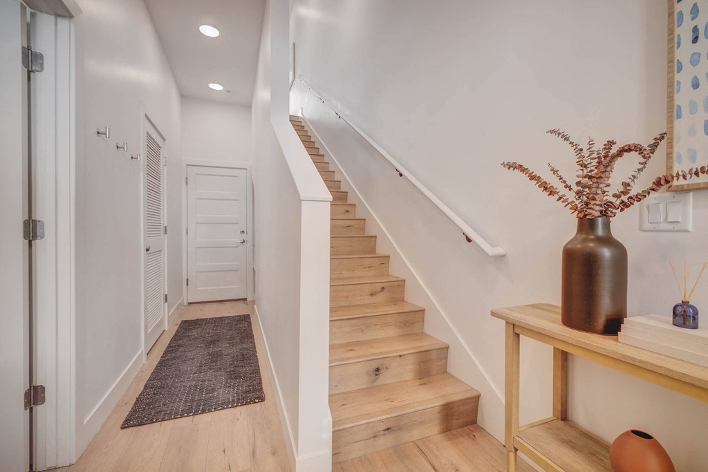 stairs in a home with white walls and wood floors