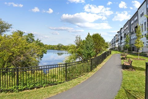 A paved walkway runs alongside a body of water.