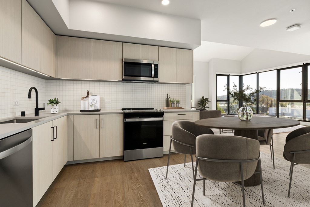 A modern kitchen with a dining table and chairs.