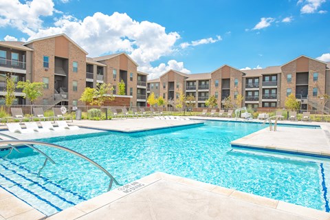 a swimming pool with an apartment building in the background