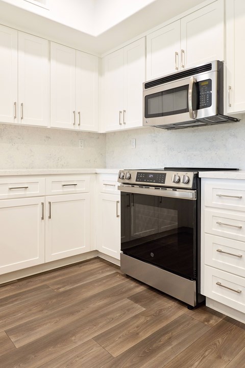 A kitchen with a stove and microwave.