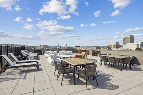 a roof top patio with tables and chairs and a view of the city