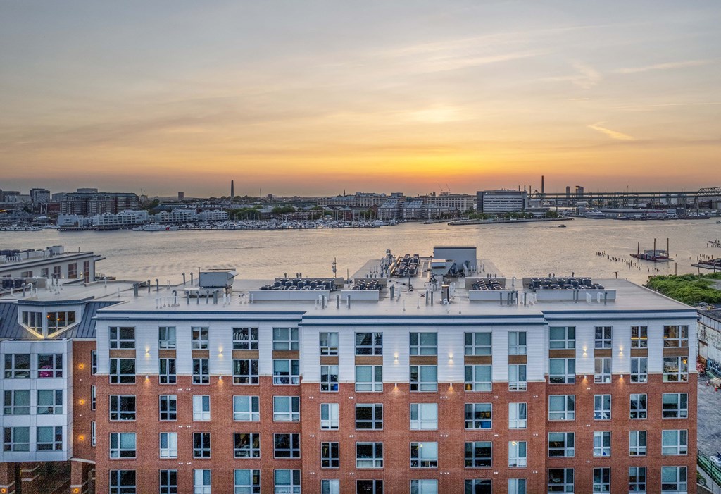 an aerial view of a large brick building with a sunset in the background