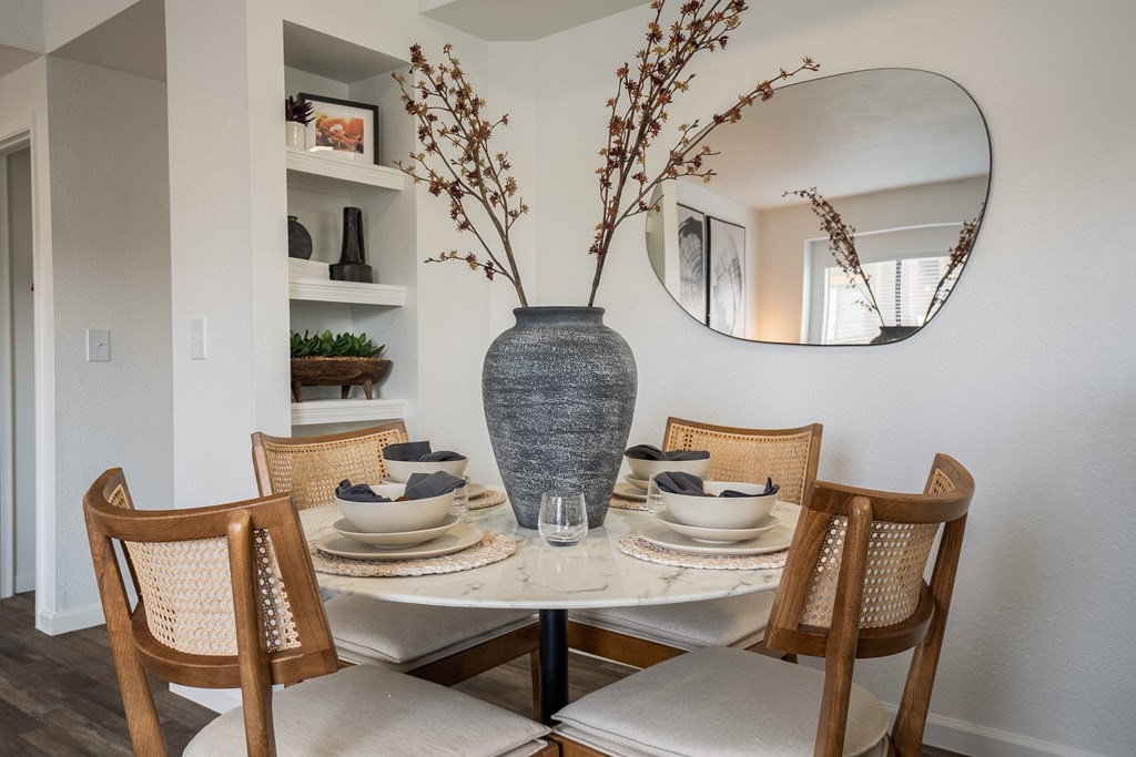 a dining room with a table and chairs and a vase