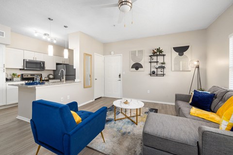 A living room with a blue chair and a grey couch.