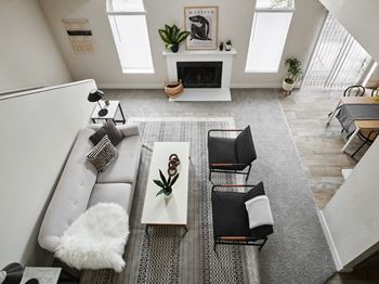 A living room with a grey couch, a coffee table, and a fireplace.