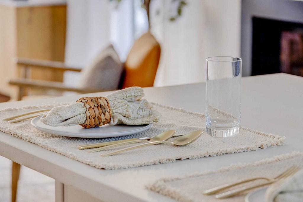 a dining table with a plate and a glass on it