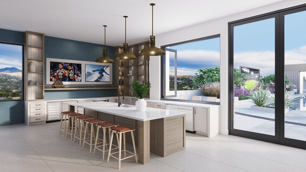 a kitchen with a large island with stools and large windows