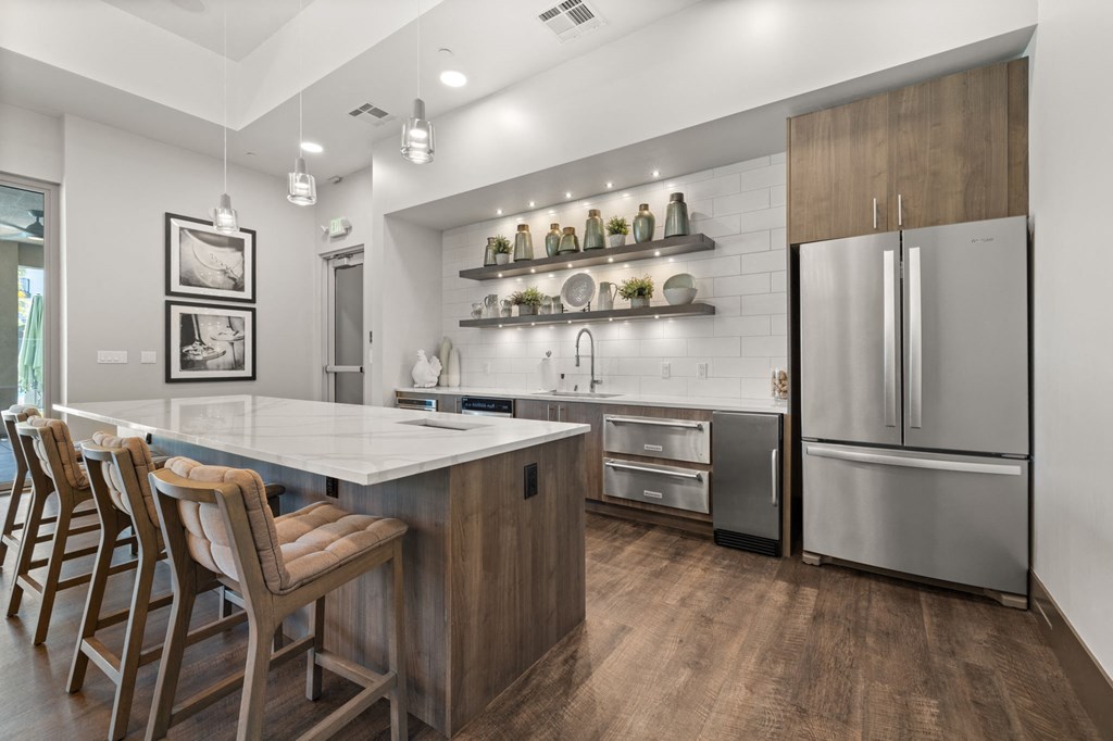 a kitchen with a large center island with a marble countertop