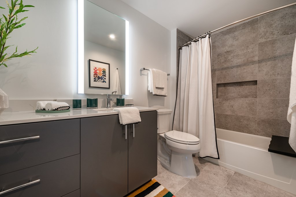 A bathroom with a toilet, sink, and shower.