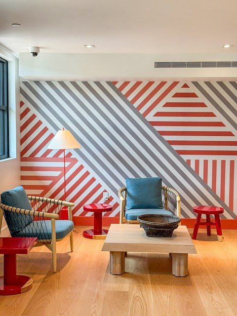 A room with a striped wallpaper and a striped chair.
