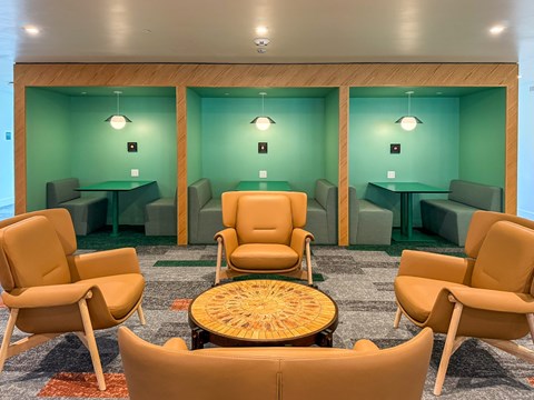 A room with green walls and tan chairs.