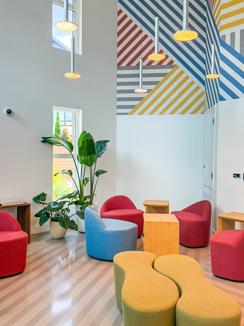 A room with a striped ceiling and colorful chairs.