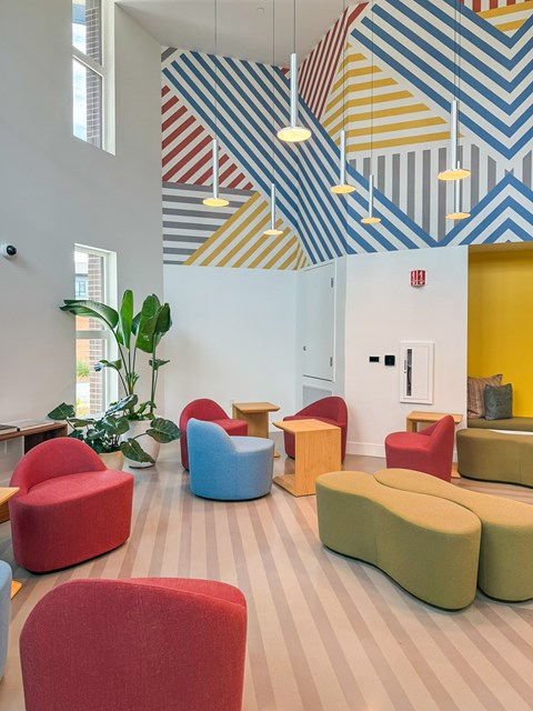 A room with a white wall and a plant in it.