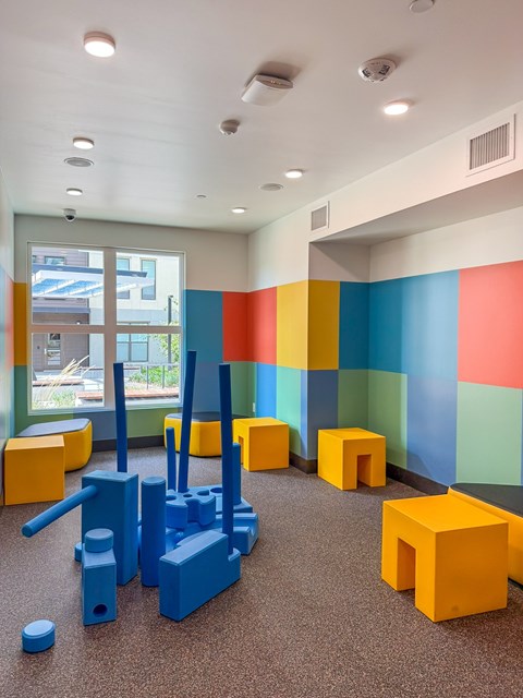 A room with a blue and orange toy set on the floor.