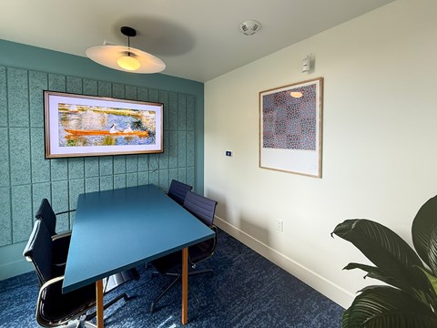 A conference room with a blue table and chairs.