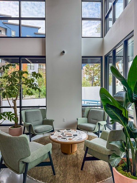 A living room with a large window and a green chair.