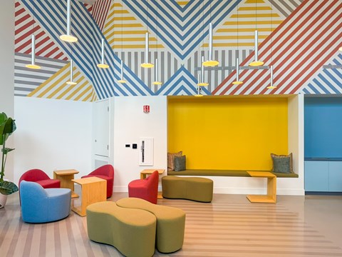 A room with colorful striped walls and a yellow bench.