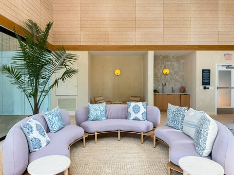 A living room with a purple couch and a white coffee table.