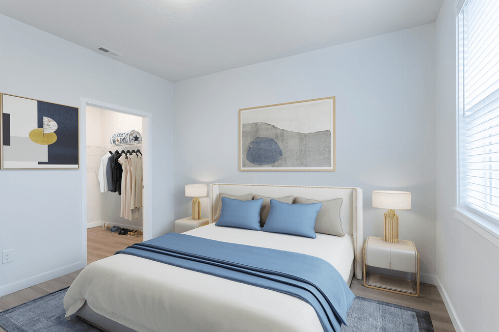 a bedroom with white walls and a bed with blue pillows