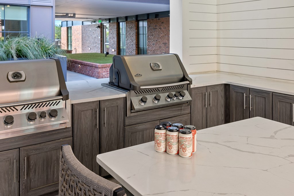 A kitchen with a grill and a table with cans on it.