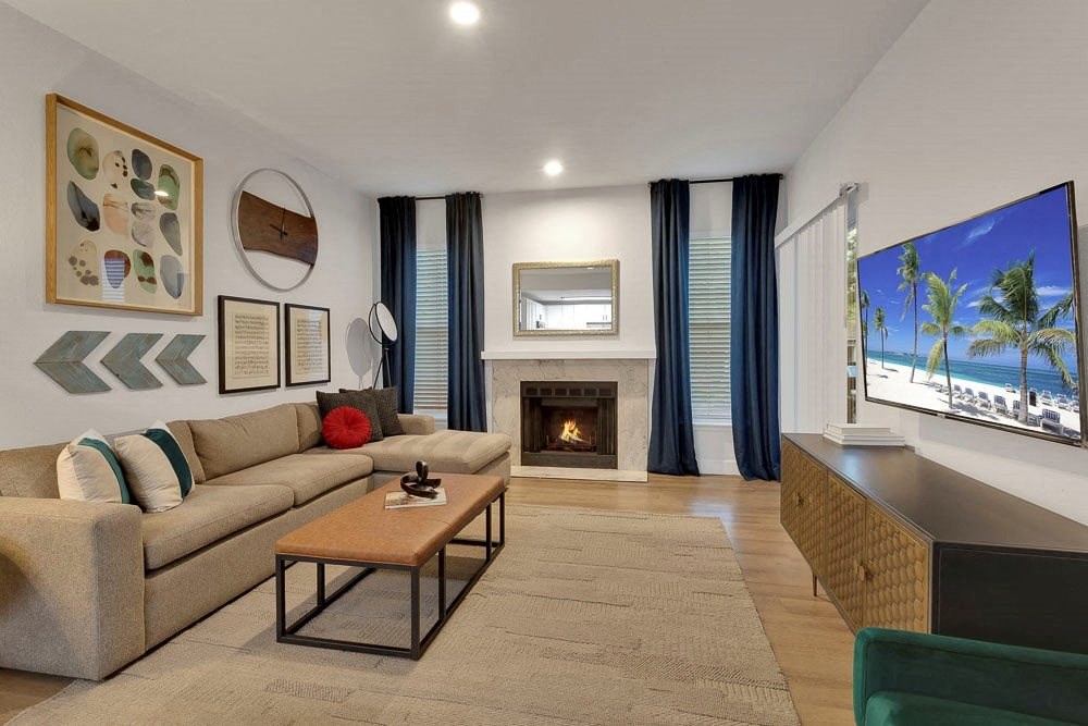 A living room with a fireplace and a flat screen TV.
