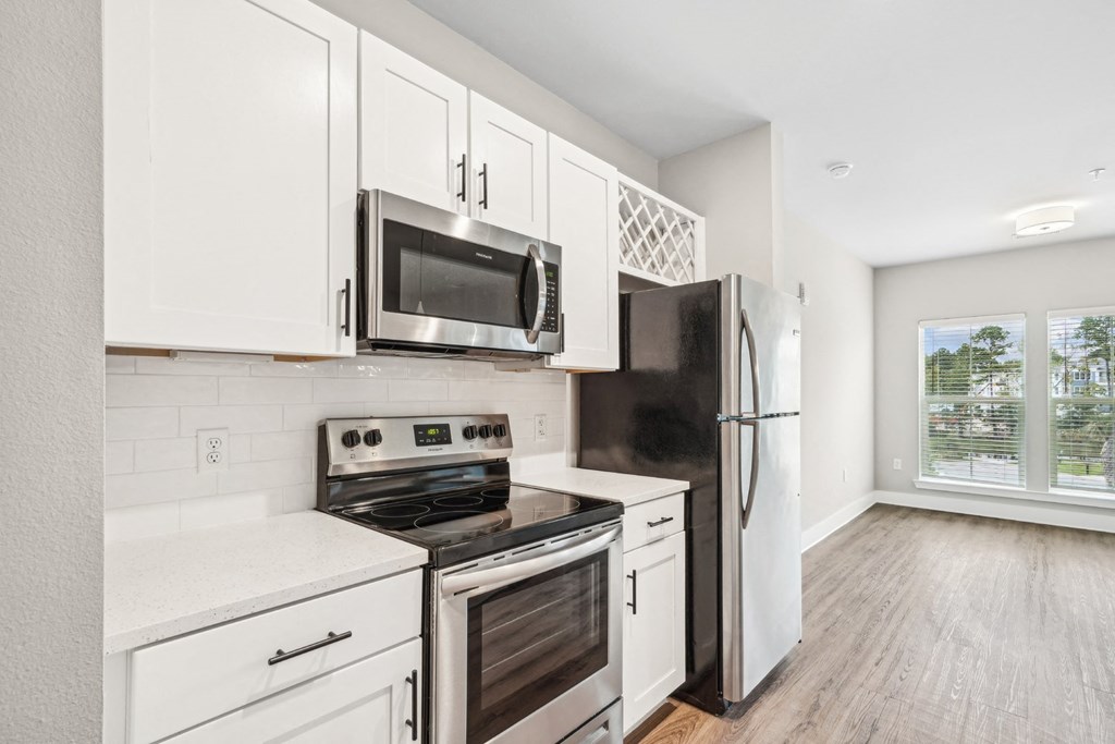 a kitchen with white cabinets and stainless steel appliances
