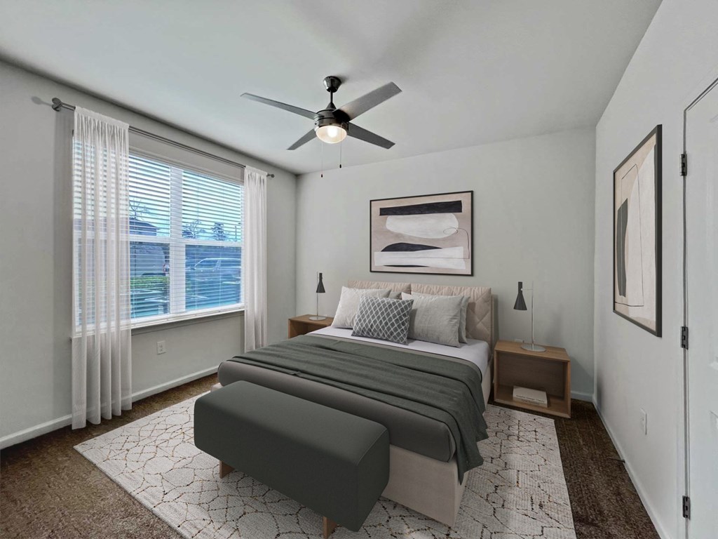 A bedroom with a large bed and a ceiling fan.