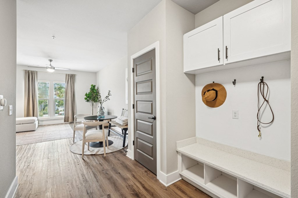 a living room with a door to a dining room and a table