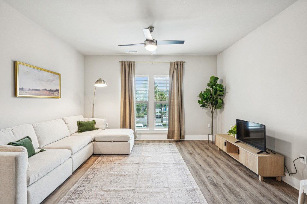 a living room with a white couch and a tv