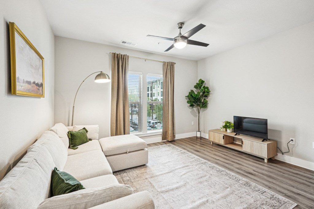 a living room with a white couch and a ceiling fan