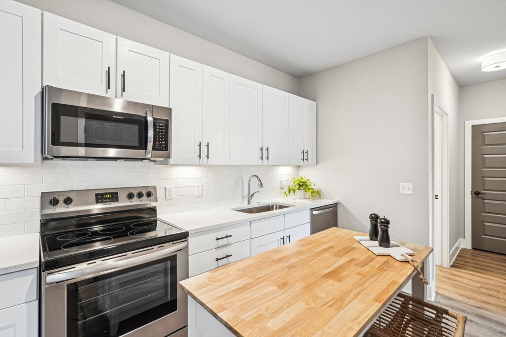 a modern kitchen with stainless steel appliances and a wooden table  and a floating island