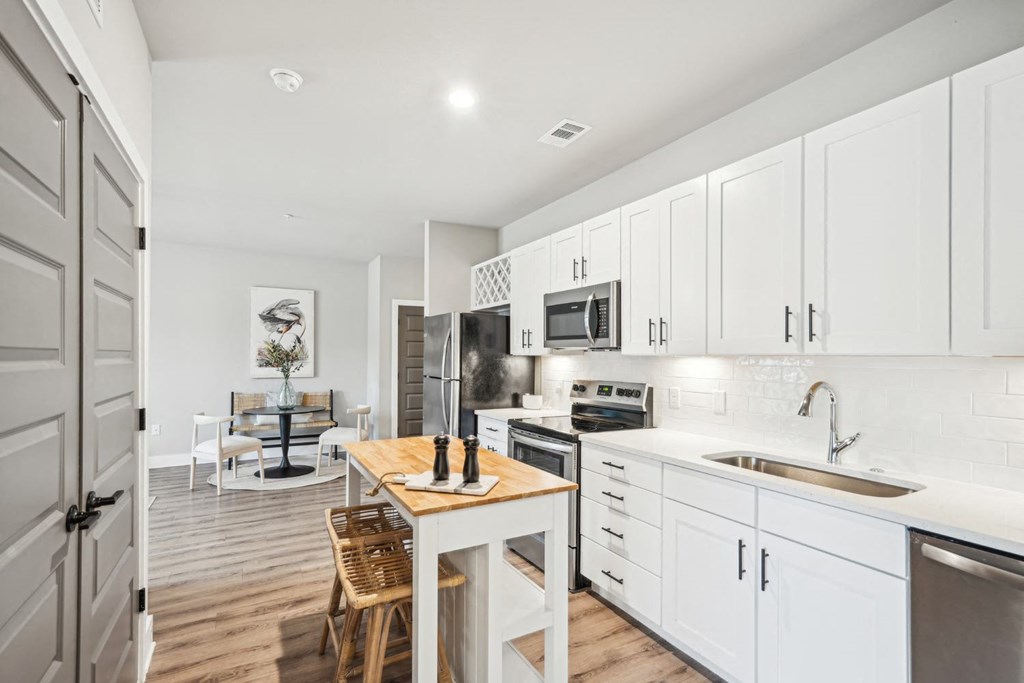 a kitchen with white cabinets and a floating island