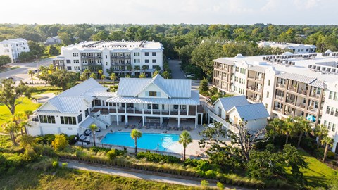 A large white building with a pool in front.