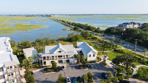 A bird's eye view of a white building with a parking lot in front of it.