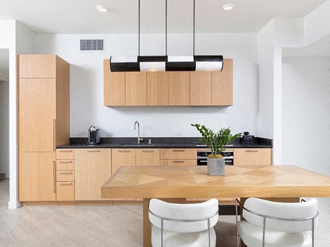 a kitchen with wooden cabinets and a table and chairs