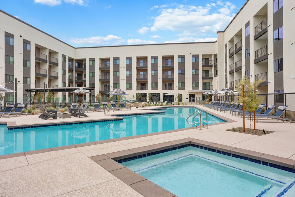 A large swimming pool in front of apartment buildings.