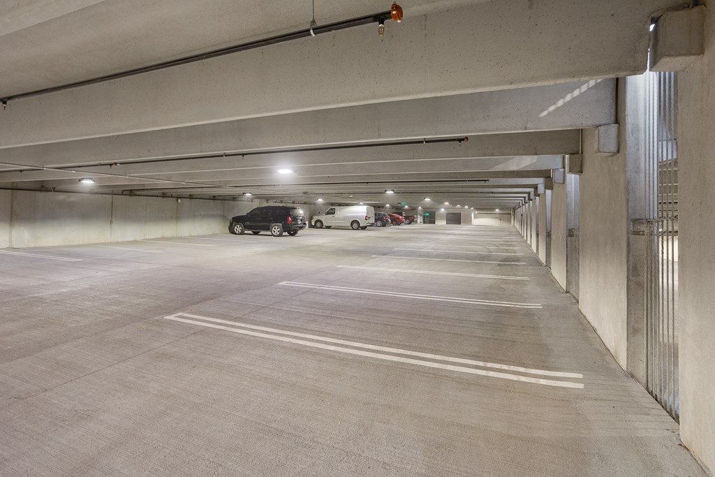 A parking garage with a few cars parked in it.