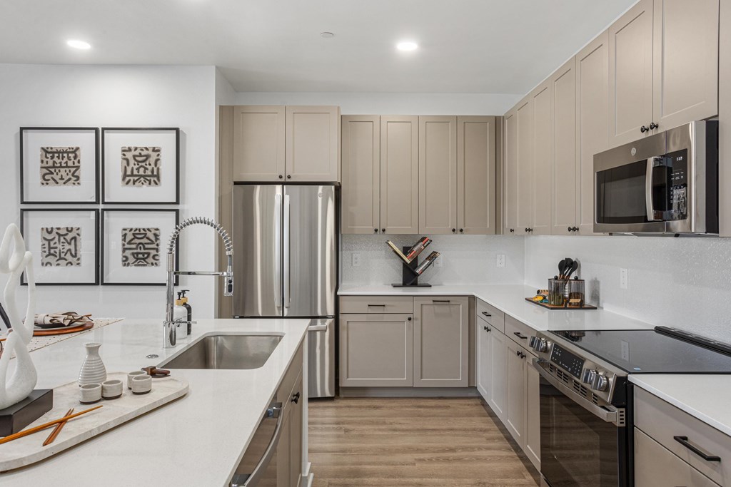 A modern kitchen with stainless steel appliances and wooden floors.